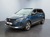La voiture bleue est garée dans une grande pièce au sol noir.