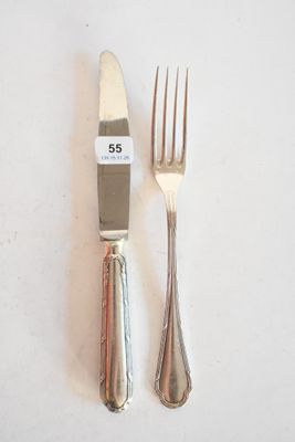 deux fourchettes et un couteau sur une table blanche