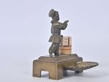 a bronze figurine of a boy on a bench