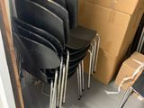 four black chairs sitting in a room with a cardboard box