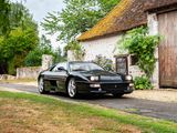 a black sports car parked in front of a house