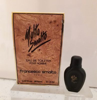un flacon de parfum posé devant une boîte sur laquelle figure une inscription