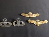 three military badges on a black surface with a black background
