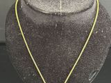 un collier en or avec un pendentif en diamant autour du cou d'un mannequin