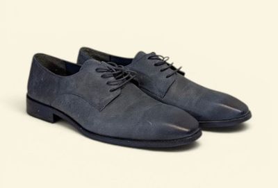 the man ' s shoes are blue and black on a white background