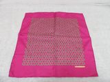 a close up of a pink scarf on a bed with a white sheet