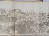 an old book with a map on it on a table