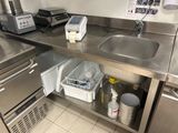 une cuisine équipée d'un évier et d'un plan de travail, avec beaucoup de vaisselle