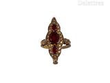 gros plan d'une bague avec une pierre rouge entourée de diamants