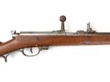 un gros plan d'un fusil sur une surface blanche avec un fond blanc