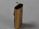 a small gold lighter that is on a table