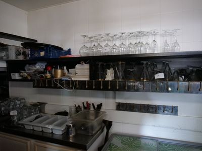 de nombreux verres sur les étagères au-dessus de l'évier de la cuisine