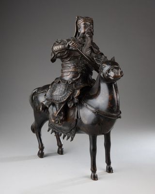 statue of a man riding a horse with a helmet on