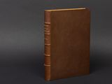 a brown book sitting on top of a black surface