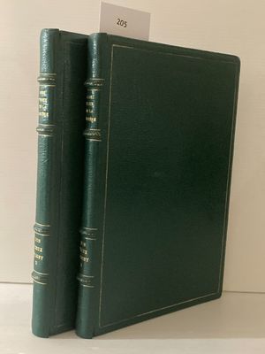 deux livres verts posés l'un à côté de l'autre sur une étagère blanche