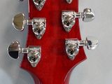 the head of a red electric guitar on a white background