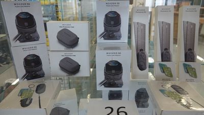 Des boîtes contenant des appareils électroniques sont exposées dans la vitrine d'un magasin