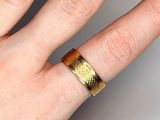 a woman ' s hand with a gold ring on it