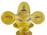 a yellow bowl with a fish design on it and a cup and saucer