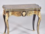 a pair of small tables with gold and black decoration