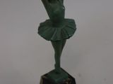 statue of a ballerina in a green tutu on a marble base