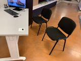 three black chairs in front of a white desk