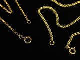 three gold chains on a black background