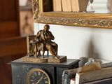 une horloge posée sur le dessus d'une étagère, à côté d'une bibliothèque