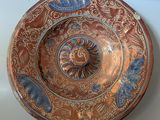 une image représentant une assiette marron et bleue posée sur une table