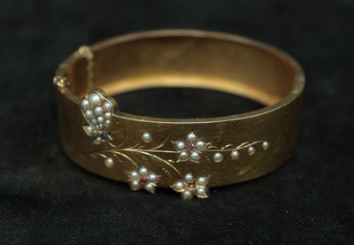 a close up of a gold ring with pearls on it