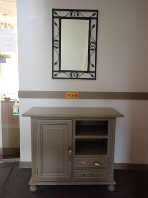 an image of a tv stand with a mirror above it