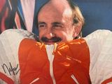 a man in an orange and white jacket with a moustache on his face