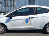 une petite voiture blanche garée dans un parking