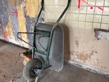une brouette dans un coin d'une pièce dont le mur est recouvert de graffitis