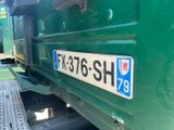 a close up of a number plate on a green train