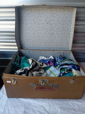 une valise remplie de vêtements posée sur un lit
