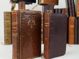 several old books are stacked on top of each other on a table