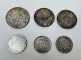 six types de pièces différents sont présentés sur une surface blanche