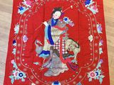 a red cloth with a woman and a dog on it