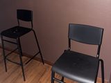 une chaise noire et un tabouret noir dans une pièce