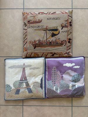 three different types of pillows on a tiled floor with a picture of a boat and a tower