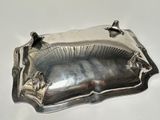 a silver plate on a white table with a silver handle