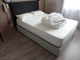 a bed with white sheets on it in a room