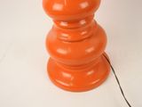 an orange table lamp that is on a white surface