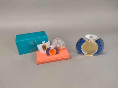 two perfume bottles sitting next to each other on top of a table