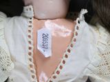 a close up of a doll with a label on it ' s neck