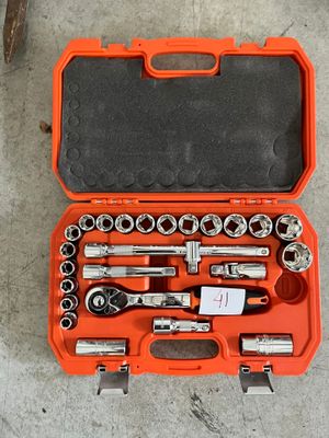 un ensemble d'outils rangés dans une boîte à outils posée par terre