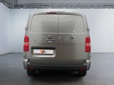 the back of a silver van parked inside of a building