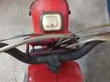 a red scooter that is parked in a garage