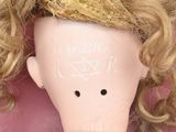a doll with blonde hair and a lace dress